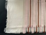 several pieces of white and brown striped fabric on a black surface