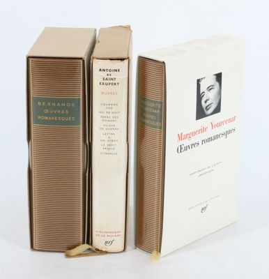 trois livres sont empilés sur une surface blanche