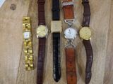 four different types of watches on a wooden table