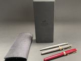 silver and red pen and pencil set in a gift box on a gray surface