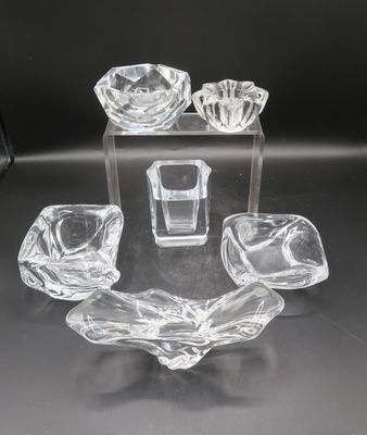 four pieces of glass on a table with a black background
