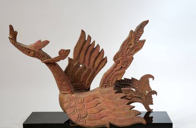 une sculpture représentant un oiseau perché sur un socle noir