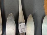 four forks and spoons sitting on a table next to each other