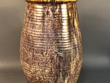 a brown vase sitting on a table with a gray background