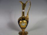 a gold vase with a black and white design on it