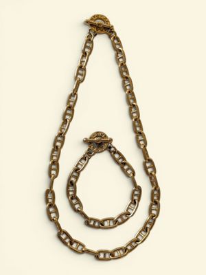 a close up of a necklace and bracelet on a white surface