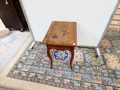 une petite table en bois avec un carreau bleu et blanc posé par terre