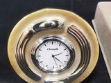 une horloge posée sur une table à côté d'une boîte