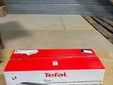 a box of tefal on the floor next to a knife