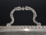 an antique silver plate with a handle on a black background