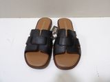 a close up of a pair of black sandals on a white surface