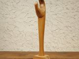 a wooden sculpture of a hand on a wooden table