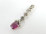 a close up of a ruby and diamond pendant on a white background