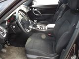 the interior of a car with the door open and the driver ' s seat down