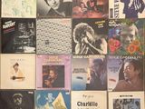 many different album covers on the wall of a room