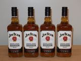 quatre bouteilles de bourbon Jim Beam posées sur une table