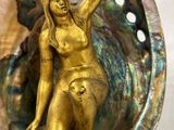 statue en laiton représentant une femme dans un coquillage, avec un coquillage en arrière-plan