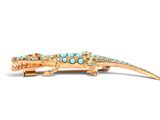 an image of a gold alligator broochle with turquoise stones