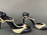 pair of black and white high heeled shoes on a gray surface