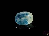 a close up of a blue and white stone on a black surface