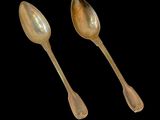 two spoons and a spoon rest on a black surface