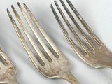 three forks sitting next to each other on a table