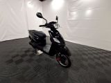 une photo d'un scooter noir garé dans une pièce
