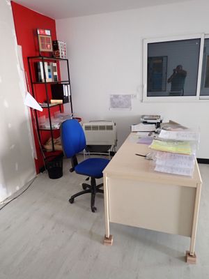 un bureau avec une chaise et une étagère dans le coin