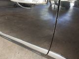 a close up of a car door handle with a reflection on the door