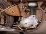 a close up of an old motorcycle parked on the street