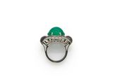 a close up of a ring with a green stone in it