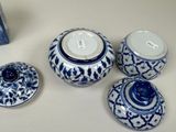 four blue and white vases and a book on the table