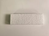 a white piece of paper on a white surface next to a toothbrush