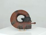 a sculpture of a bird sitting on top of a piece of wood