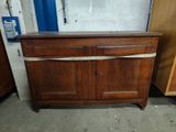 a wooden cabinet that is in the corner of a room