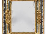 a close up of a mirror on a white surface with a gold frame