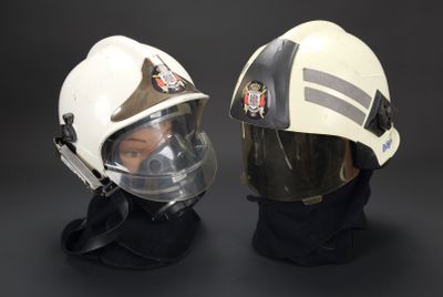deux pompiers portant un casque et des lunettes de protection, sur fond noir