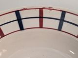a white bowl with red and blue stripes on it