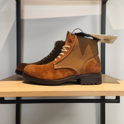 des bottes marron exposées sur une étagère dans un magasin de chaussures