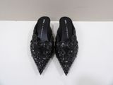 a pair of black shoes sitting on top of a white surface