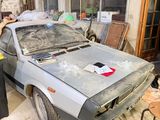 un homme debout à côté d'une voiture dans un garage