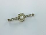 a close up of a small white pearl and diamond broocher