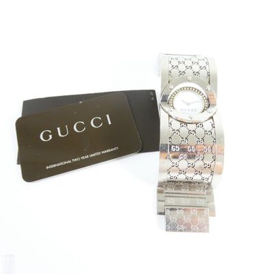 a gucci watch and a card on a white surface