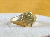 an image of a gold signet ring on a piece of wood