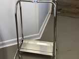 une table en verre surmontée d'une étagère en métal
