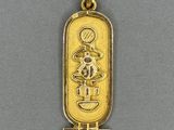 a gold plated pendant with an egyptian symbol on it