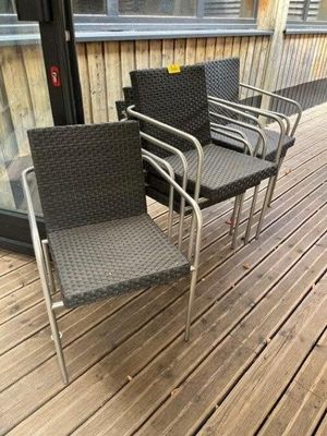 three chairs sitting on a wooden deck next to a glass door