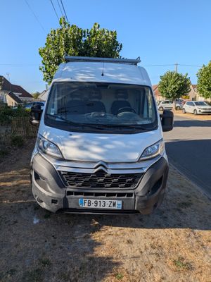 a white van parked on the side of a road next to a tree