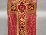 a close up of a red and gold cross on a mannequin