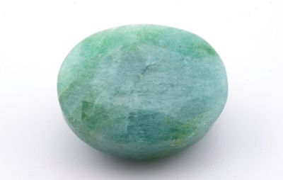 une boule verte sur une surface blanche, avec un fond blanc